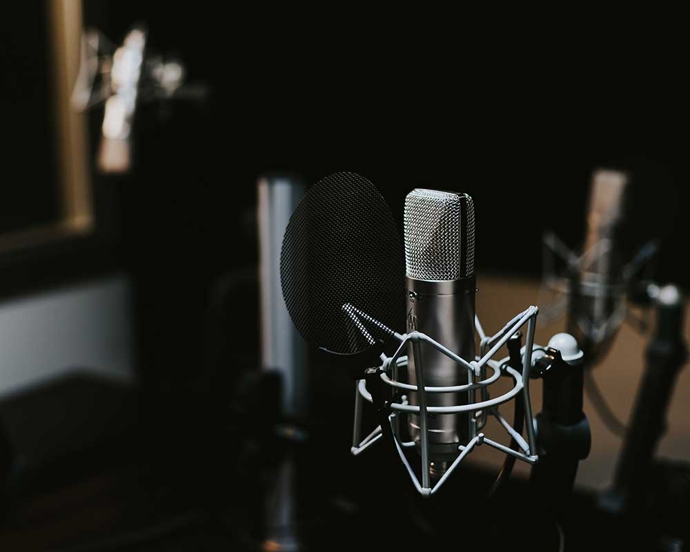 A silver microphone in a recording studio.