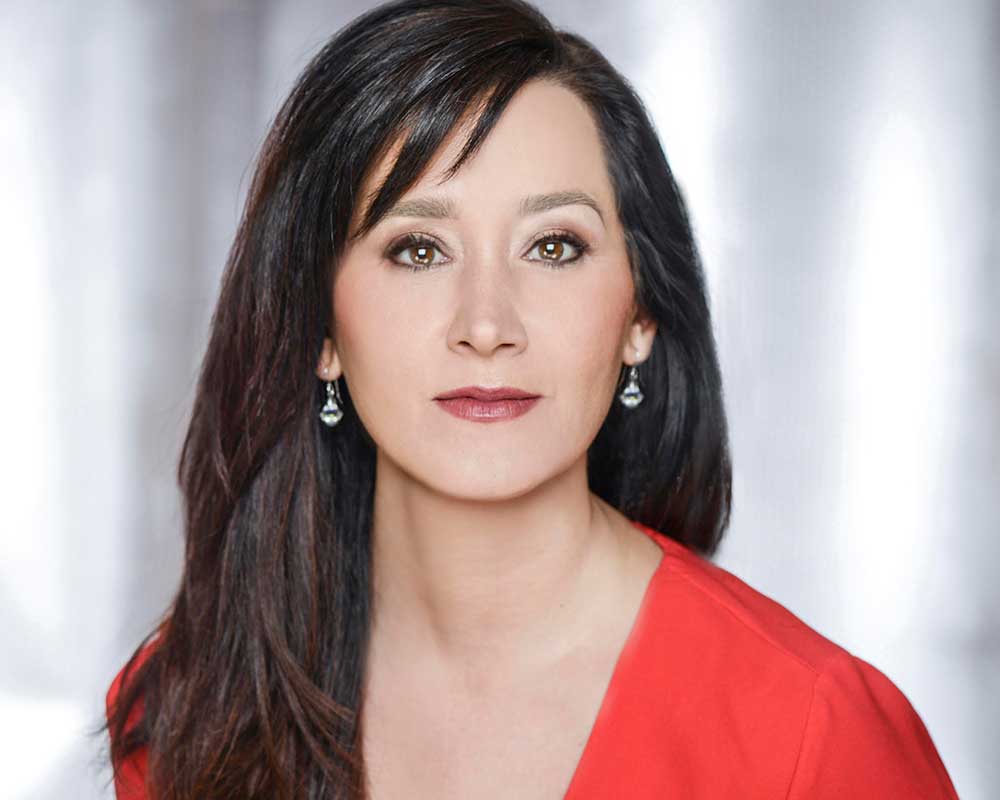 Headshot of woman with long dark hair wearing a red shirt.